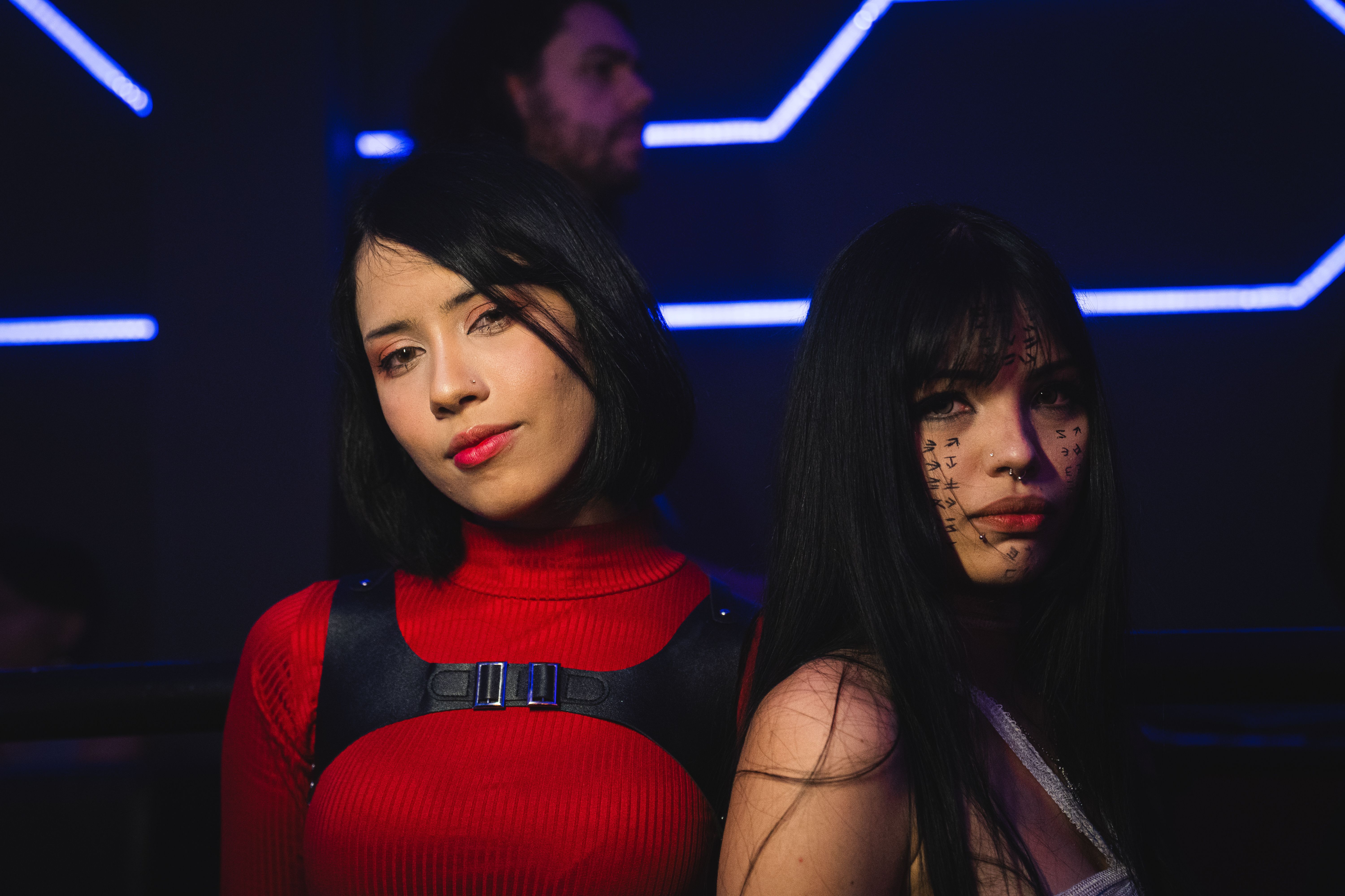 Participantes em meio à iluminação colorida da festa.