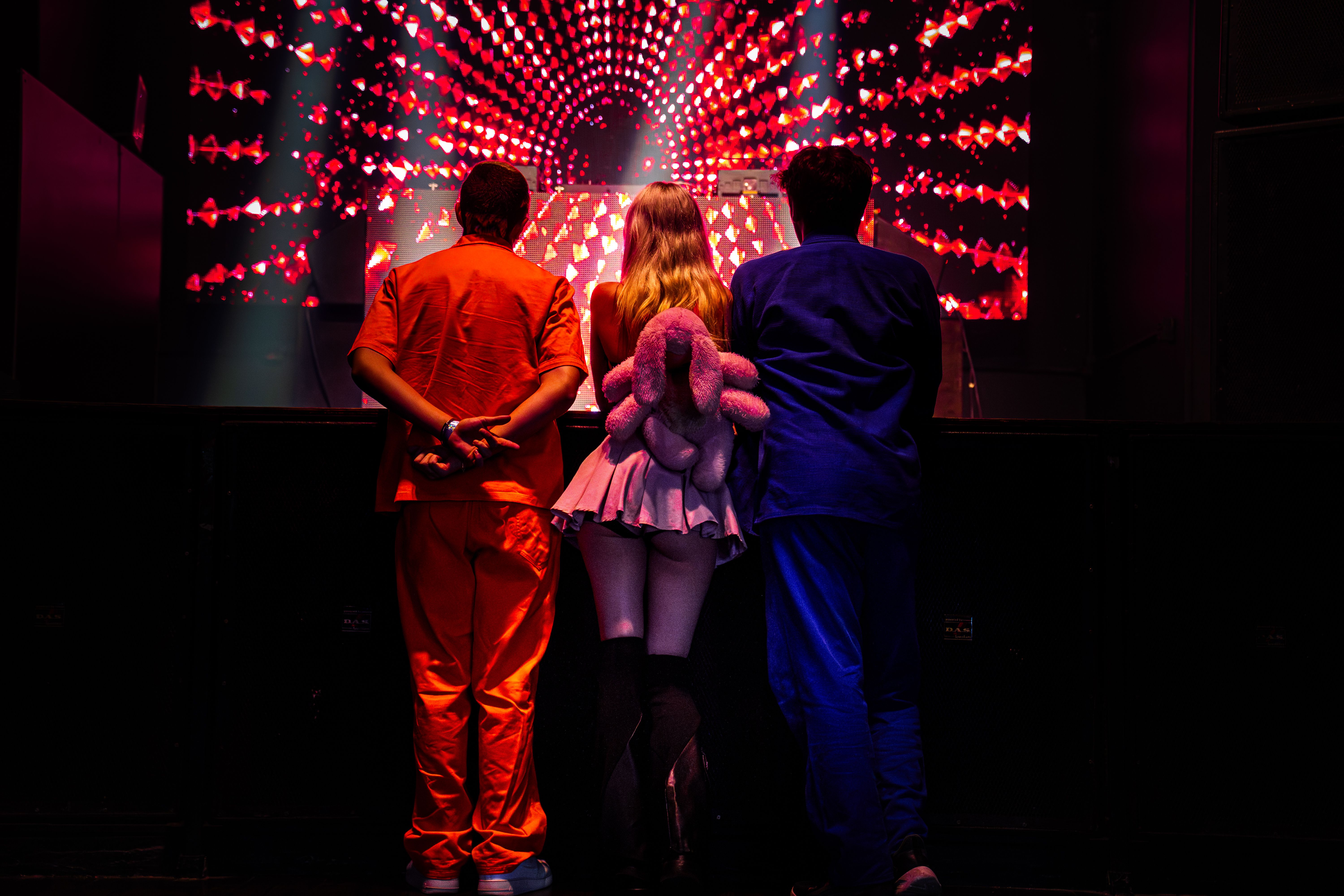 Participantes em meio à iluminação colorida da festa.
